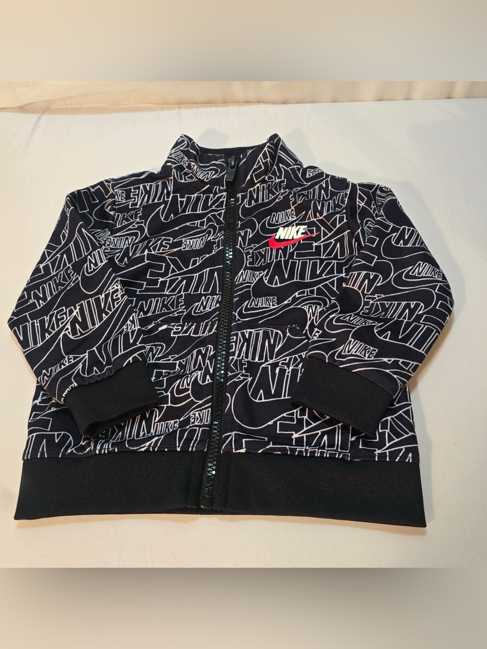 Nike Black Kids' All-Over Logo Zip-Up Jacket with White Script and Red Accent